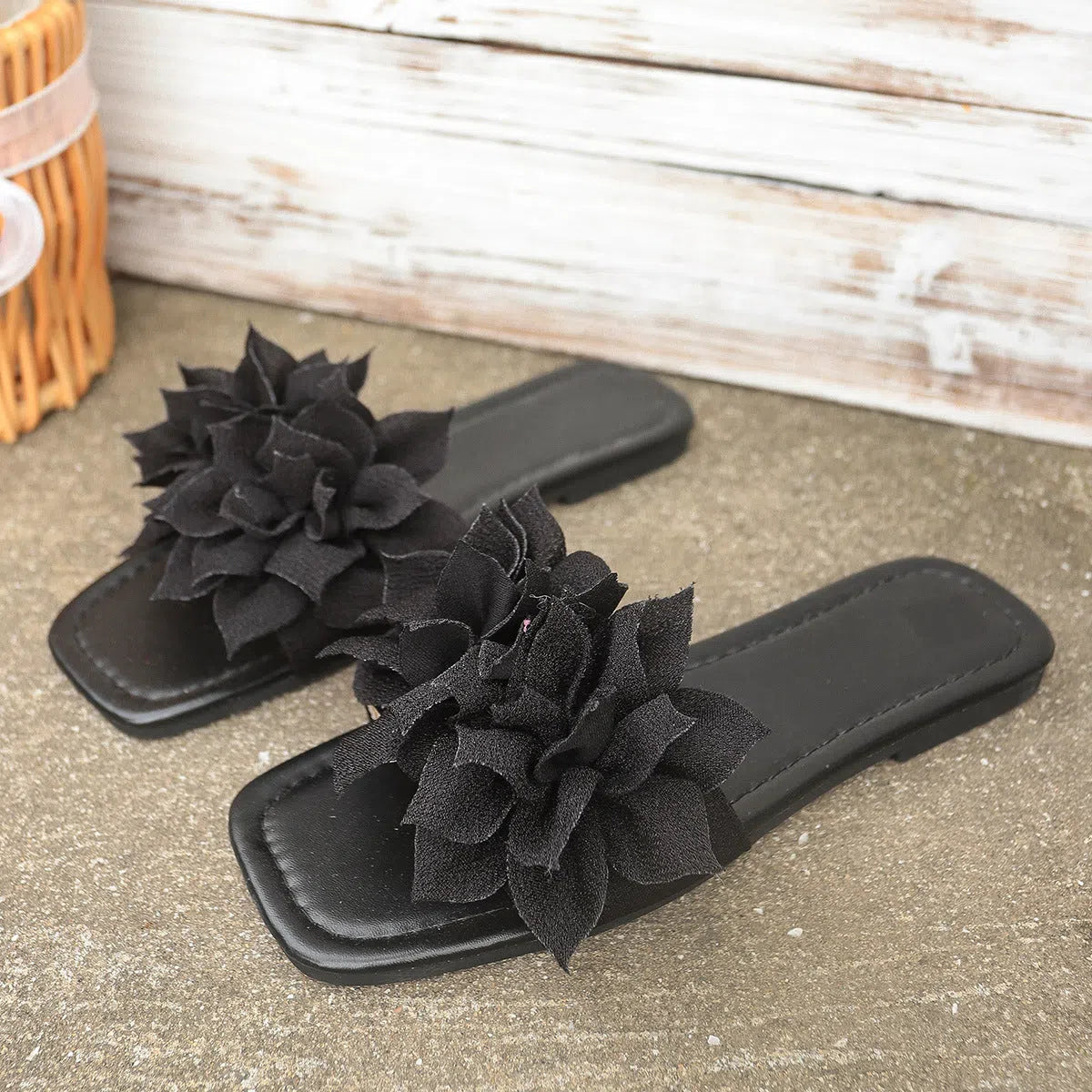 Flat flip-flops with flower decoration in faux leather and rubber sole in black colour for women