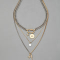 Alloy multi-layer twin necklace with geometric elliptical pendant on a white background