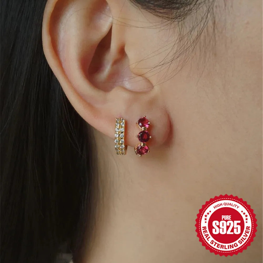 Close-up of geometric sunflower design sterling silver earrings with golden zircon stones.