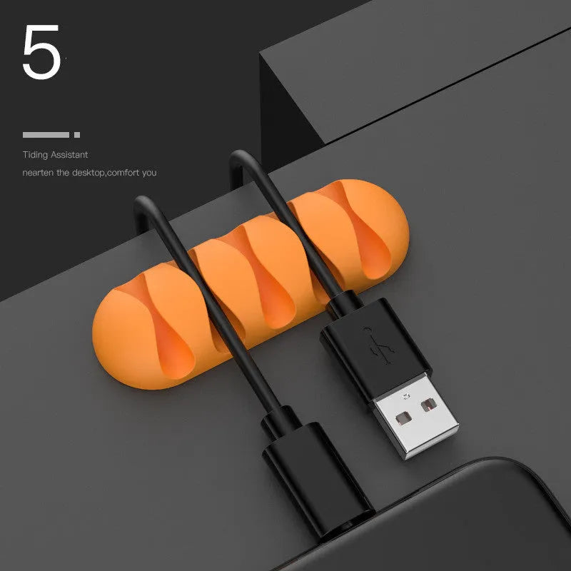 Smart cable holder with TPR flexible clips in black holding USB earphone and network cables on a desk