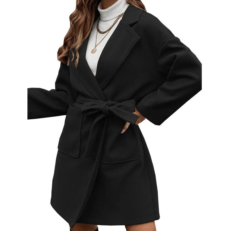 Long sleeve loose fit lapel coat with button front, split hem, and self-tie belt in thick polyester fabric.