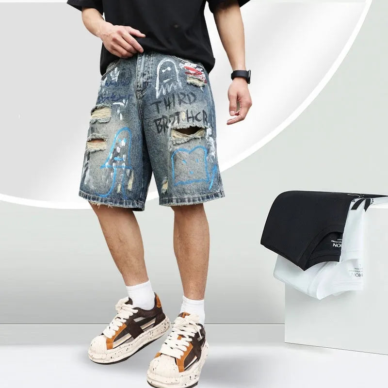Men's blue ripped denim shorts with graffiti design and straight leg.