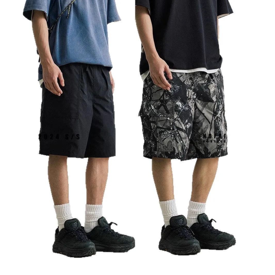 Man wearing loose straight-leg denim shorts in army green, showing mid waist and casual style.
