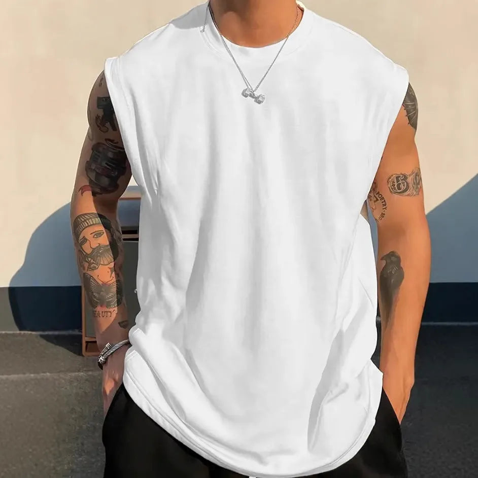 Men's loose-fitting solid colour cotton tank top on a hanger, shown in a light colour.