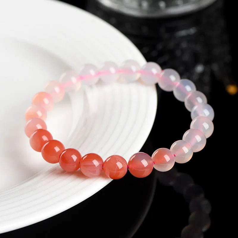 A gradient colour agate bead bracelet on a wrist, showing natural stone banding.