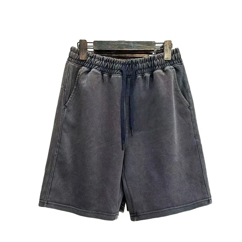 Men's solid colour distressed cotton shorts in a loose straight-leg casual fit.