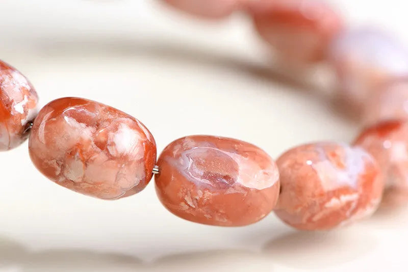 Natural cherry agate barrel bead bracelet with Ruyi decoration on white background