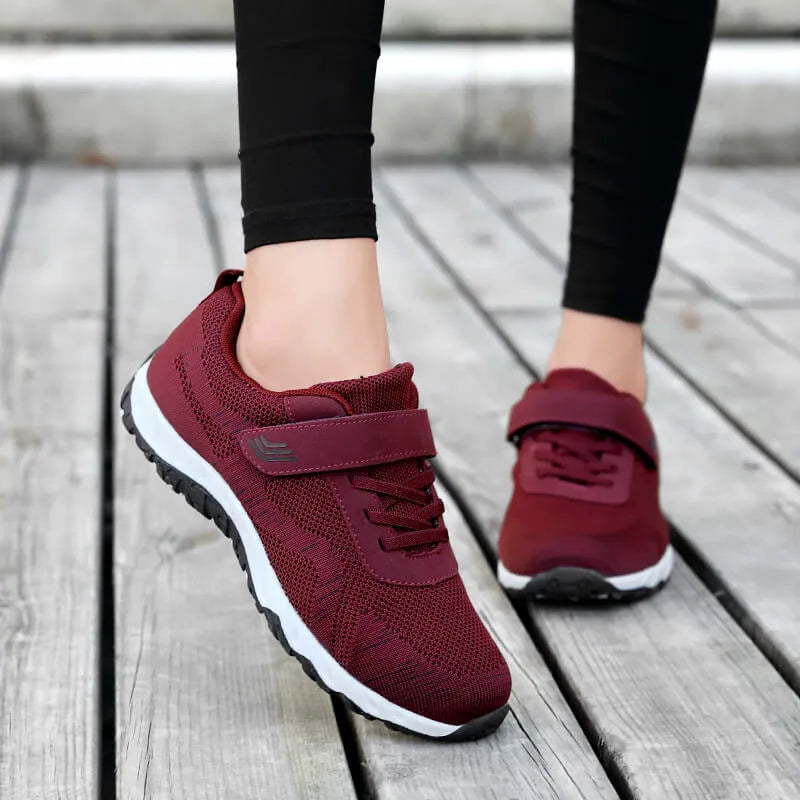 Women's grey purple low-top casual shoes with Velcro strap and wedge heel on a plain background.
