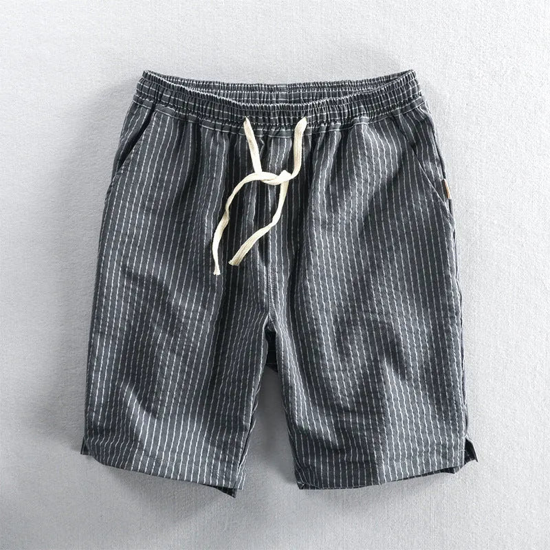 Man wearing black and white striped loose-fit casual cotton shorts with a mid waist.