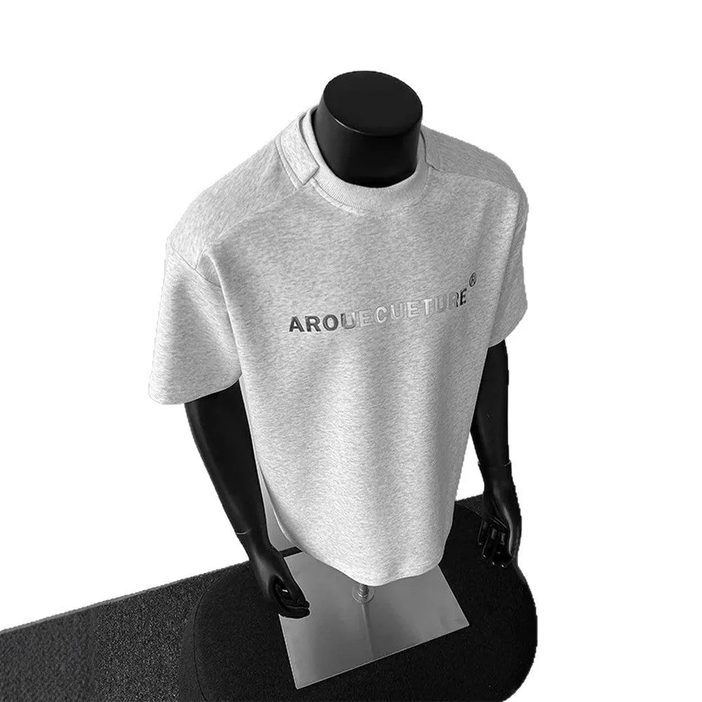 Man wearing a loose-fit black t-shirt with a white letter print on the chest.
