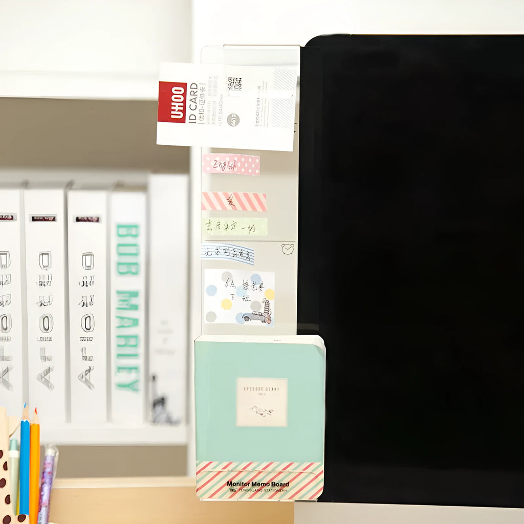 Acrylic monitor message memo board attached to monitor with wall suction, holding a post-it note