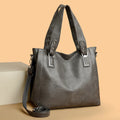 Women's soft PU handbag in horizontal square shape with sewing thread detail and single shoulder strap.