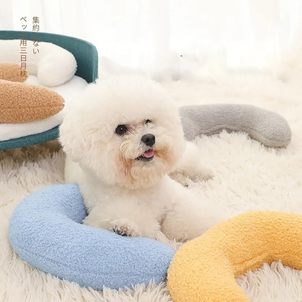 Blue U-shaped cat pillow with an integrated adjustable fabric collar on a grey blanket