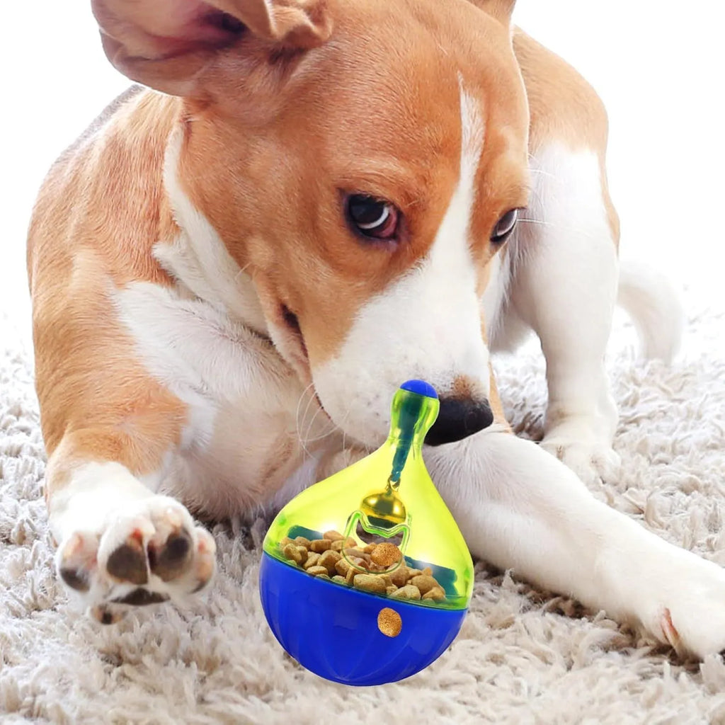 Blue tumbler-shaped pet treat dispenser toy for dogs and cats on wooden floor