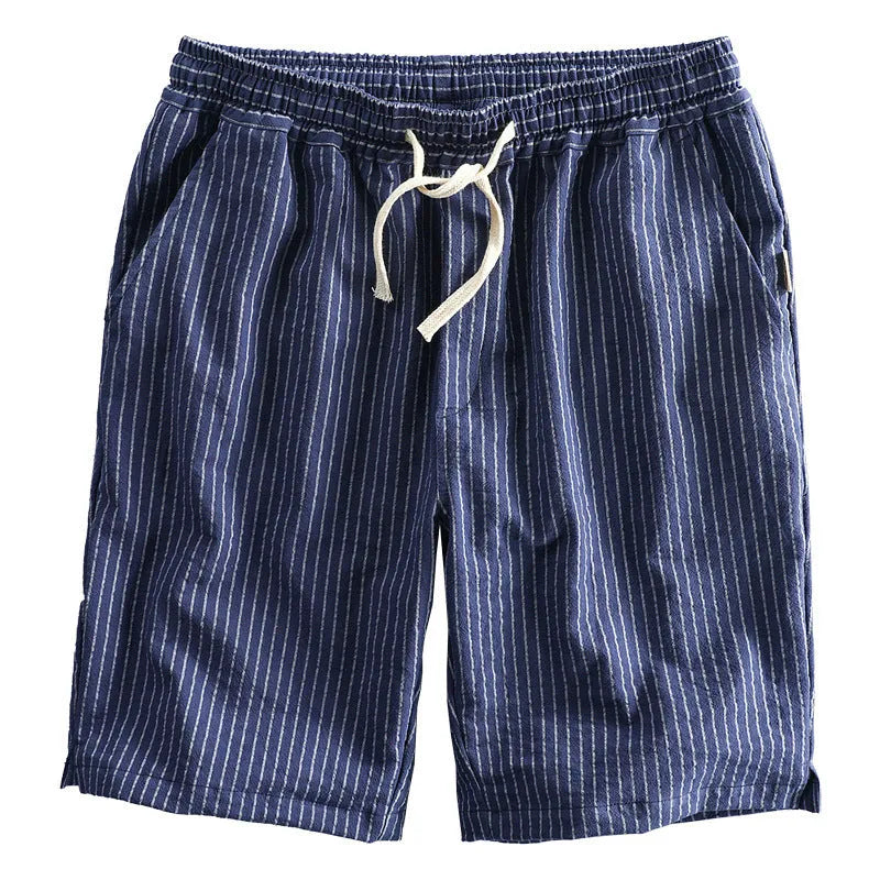 Man wearing black and white striped loose-fit casual cotton shorts with a mid waist.