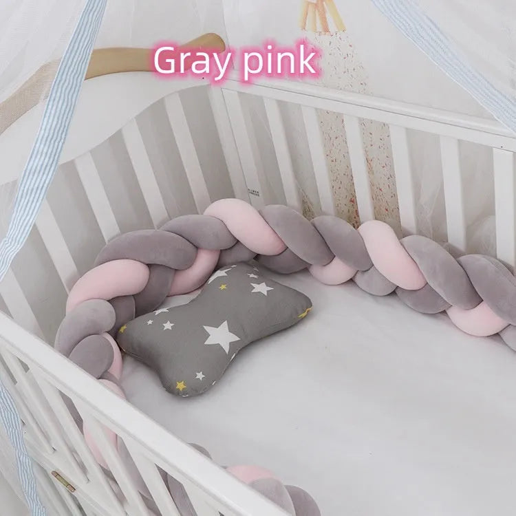 Braided knot crib bumper in spandex velvet, shown bending to fit a white wooden cot.