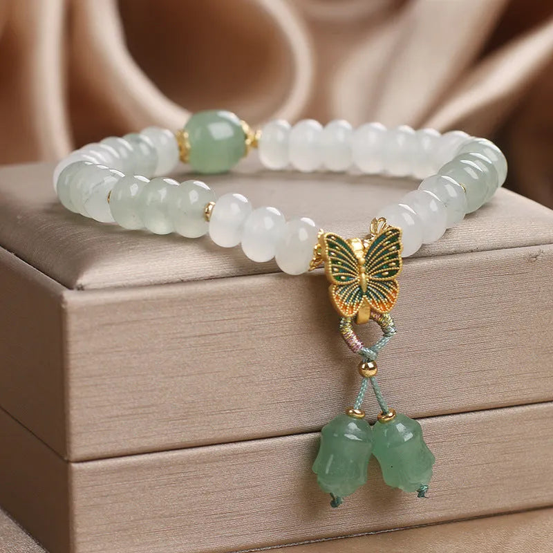 Green crystal Tian Shan Cui abacus bead bracelet with a retro butterfly tassel and pearl detailing.