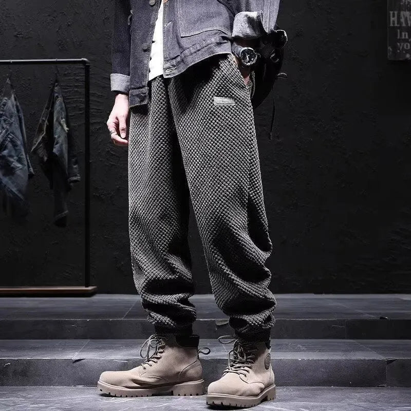 Men's grey ankle-tied straight-leg sweatpants laid flat, showing the tapered cut and tie detail.