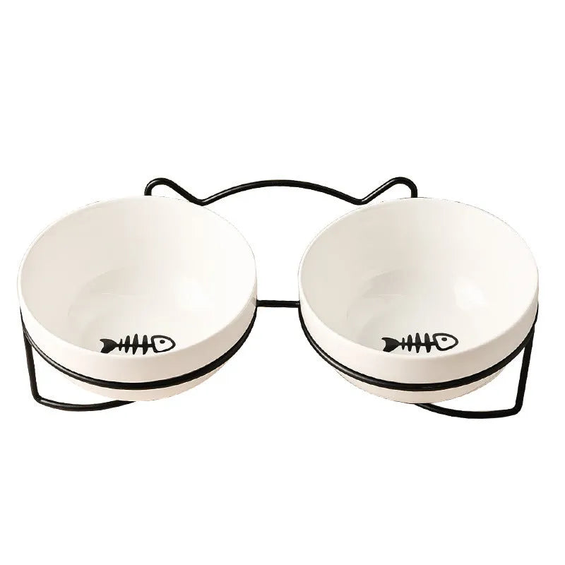 White ceramic cat bowl with cat paw print design on a black iron frame stand