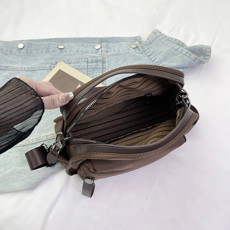Vegan leather crossbody bag in black with double-stitched contrast thread, YKK zippers, and reinforced base