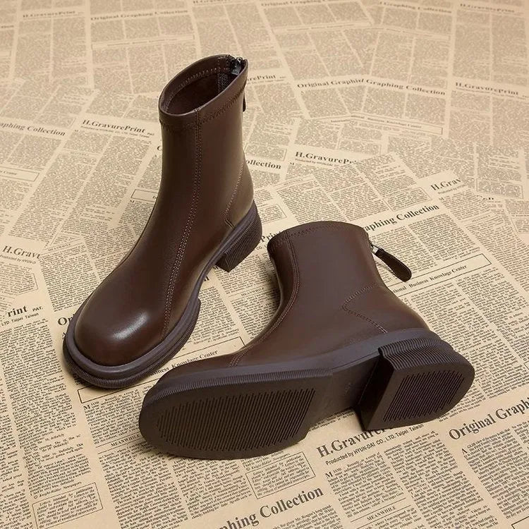 Women's black ankle boots with a flat thick heel, round toe, and a back zipper closure.