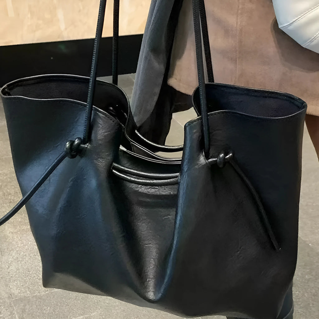 Black PU leather commuter bag with double shoulder straps and solid colour finish, front view