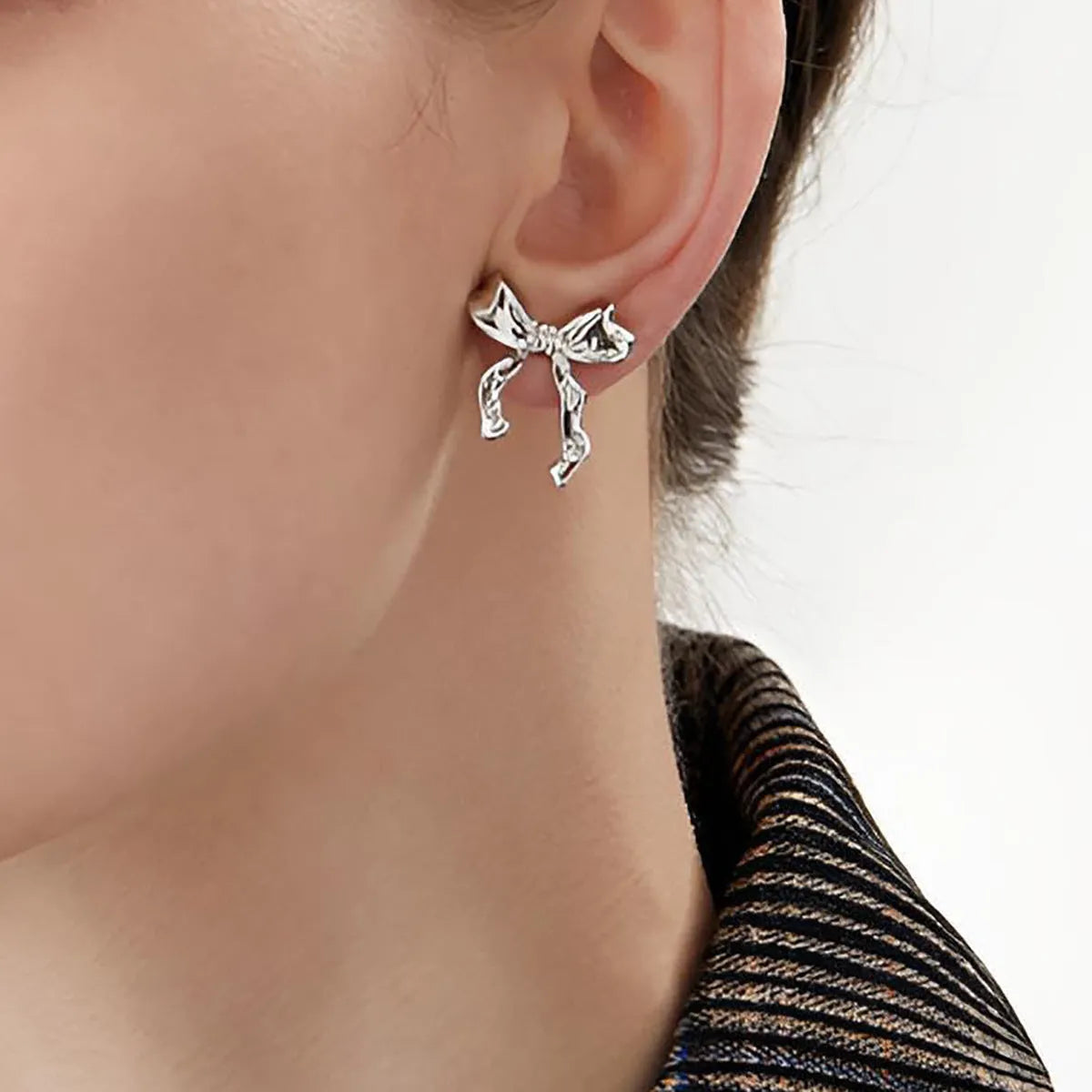 Gold bow earrings simple style alloy electroplated finish pair on white background