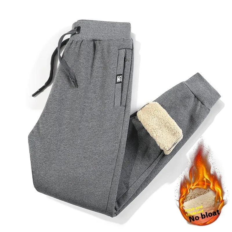 Men's grey fleece-lined cotton oversized track pants on a hanger, showing mid waist and straight leg.