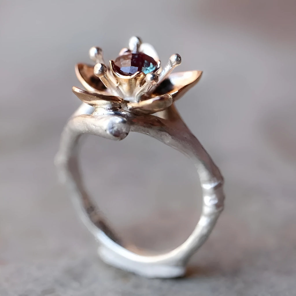 Silver coloured women's alloy ring with geometric shape and two-tone floral design on a white background.