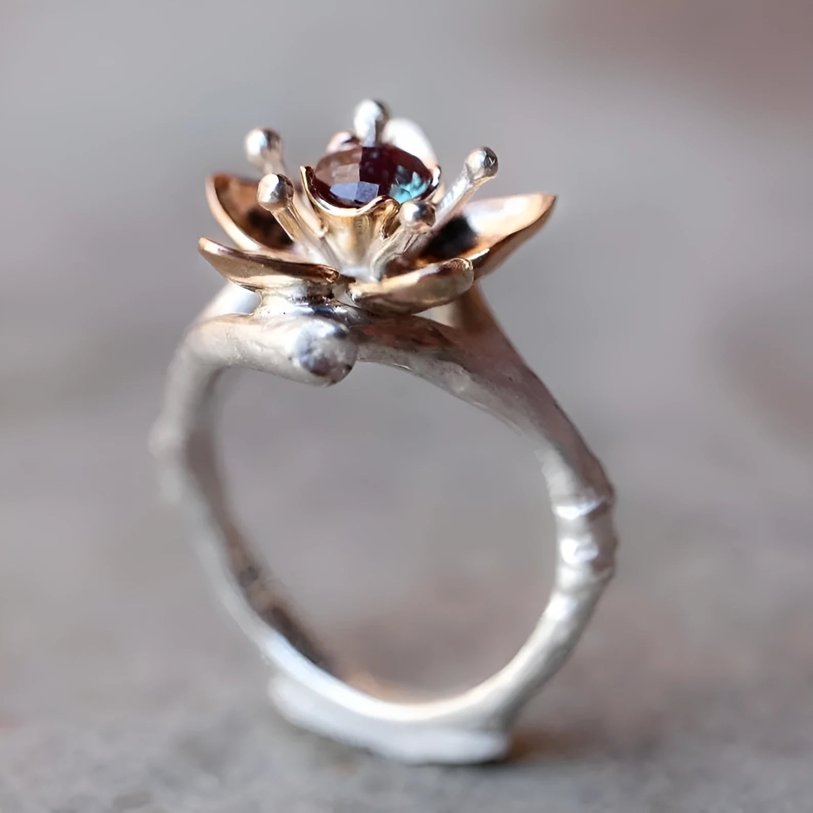 Silver coloured women's alloy ring with geometric shape and two-tone floral design on a white background.
