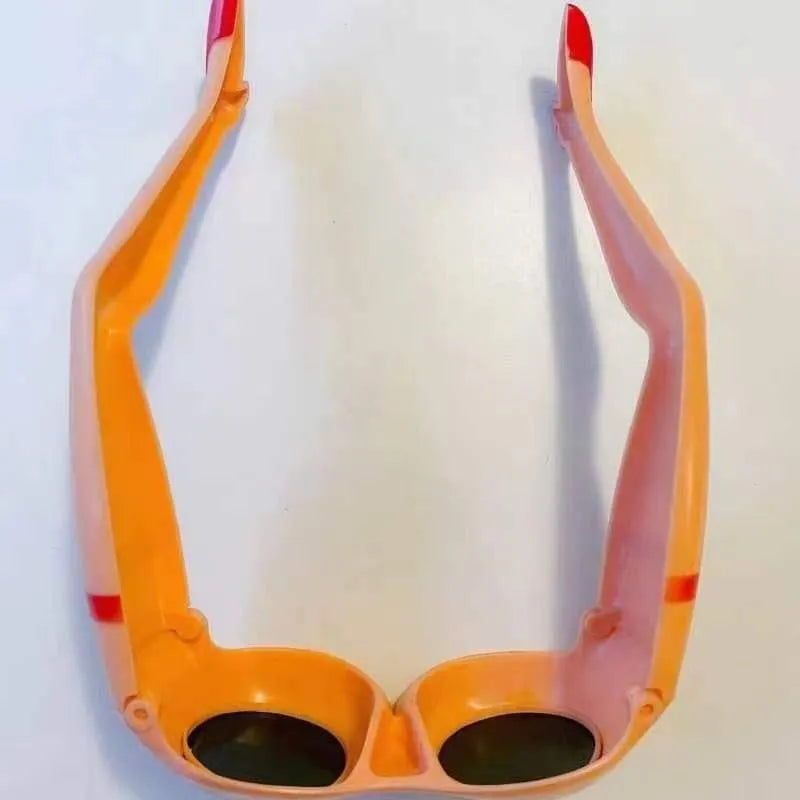 Orange plastic novelty sunglasses with leg and hip design on frame