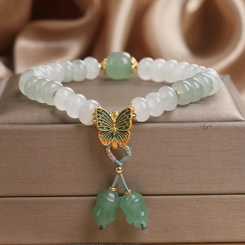 Green crystal Tian Shan Cui abacus bead bracelet with a retro butterfly tassel and pearl detailing.
