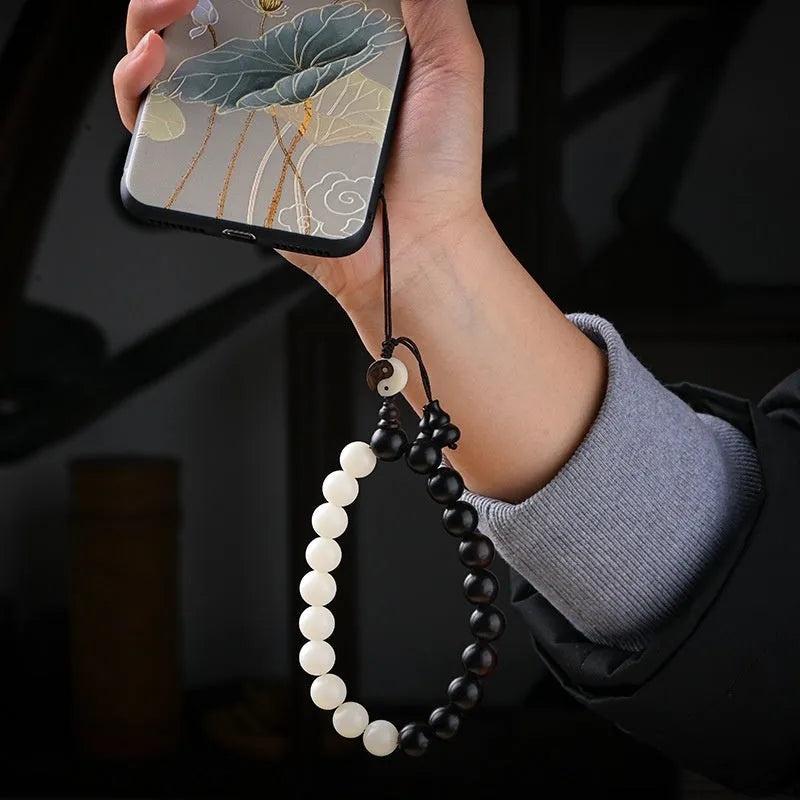 White and black bodhi seed bracelet with eight-diagram pattern, shown as a bracelet and lanyard.