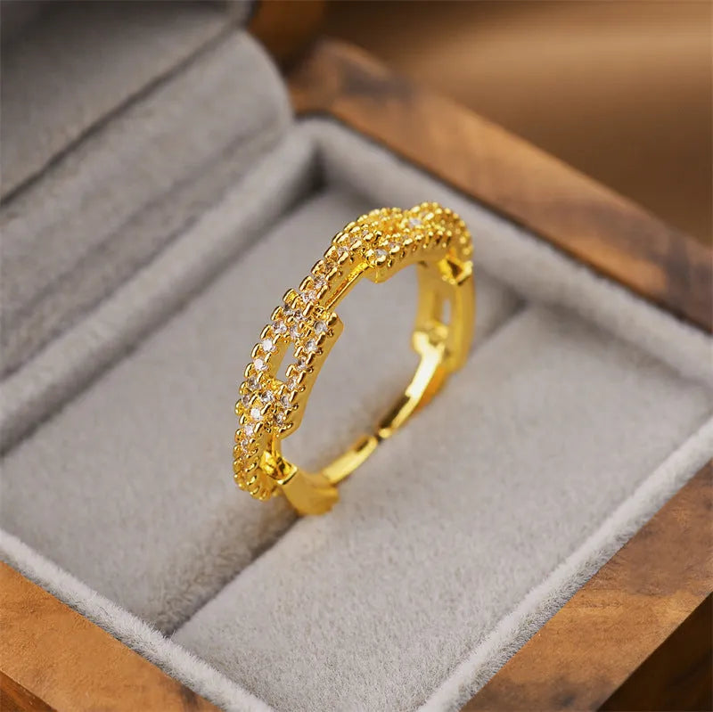 Gold geometric open ring for women on a grey background.