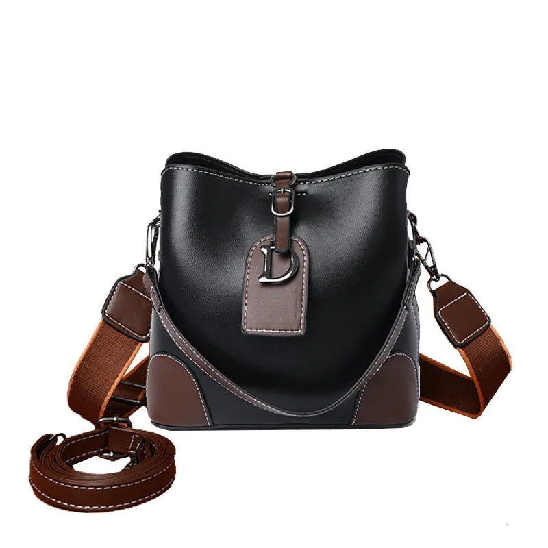 Women's soft PU bucket bag with tassel and contrast colour stitching on a plain background