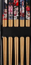 Set of five pairs of bamboo chopsticks with Japanese lucky cat and elegant blue patterns on a table.