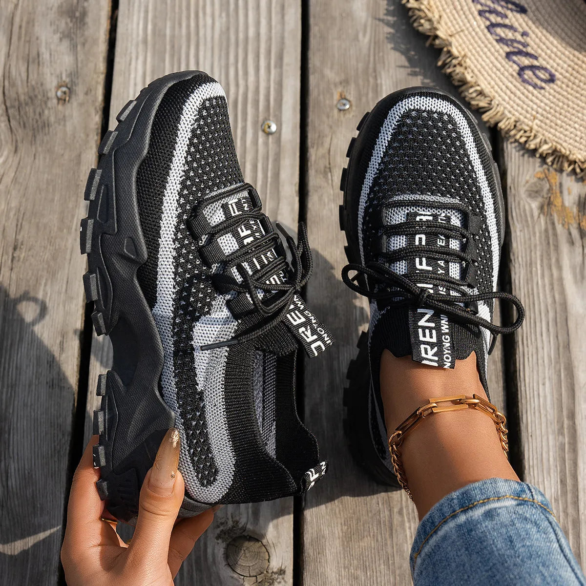 Women's lace-up Flyknit mesh sneakers in a grey colour combination with a round toe and flat rubber sole.
