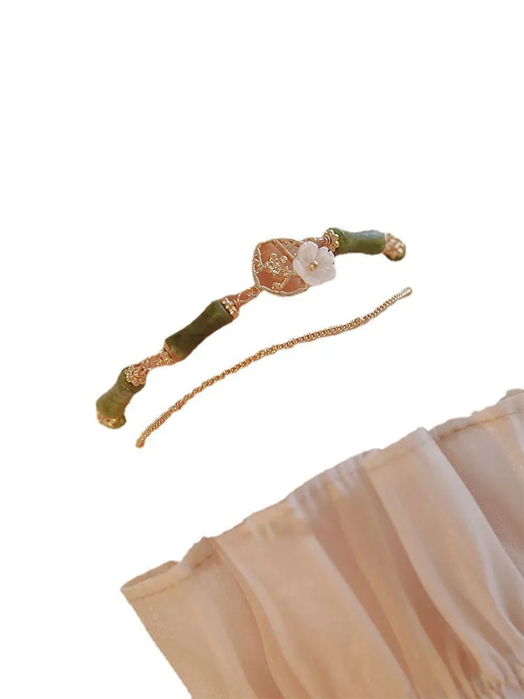 Natural olivine gemstone bracelet with double layers and twin Bells of Ireland charms on a wrist.