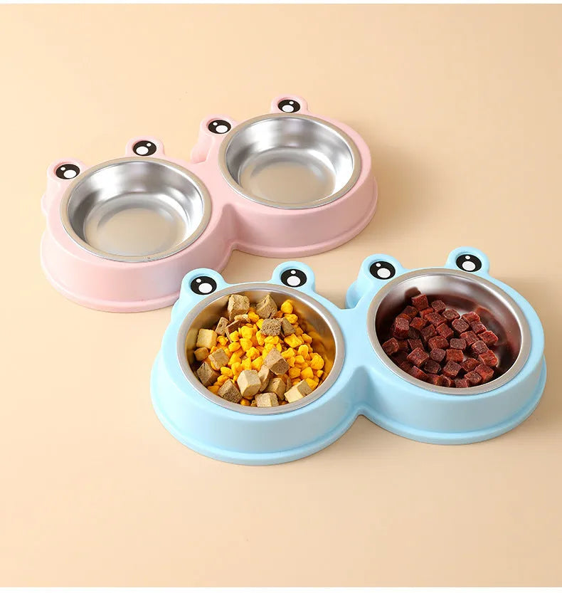 Frog-shaped plastic holder containing two stainless steel pet bowls for food and water.