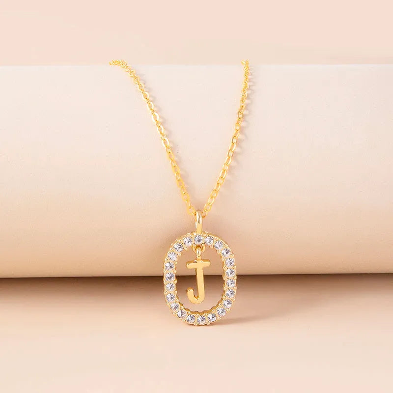 Gold crystal letter initial oval pendant necklace on woman, rhinestone letter in zinc alloy frame with adjustable chain