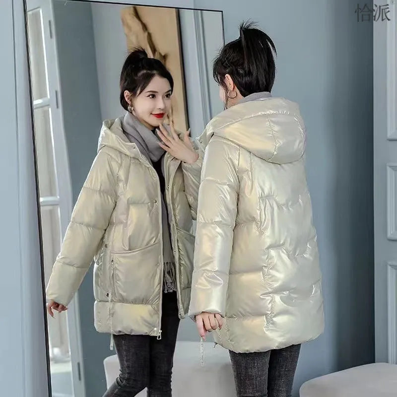 Woman wearing a loose-fit green hooded winter jacket with long sleeves.