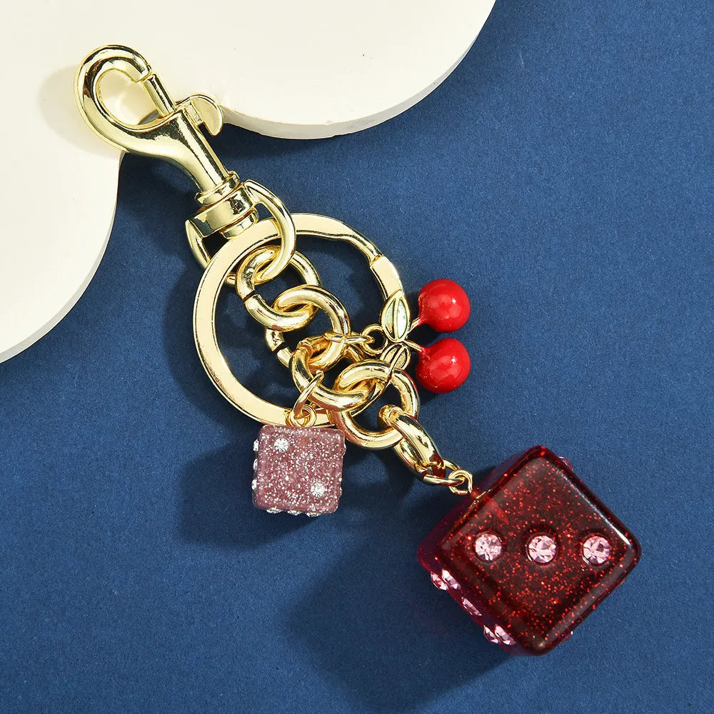 Square metal keychain pendant with cherry two-tone dice design and electroplated finish