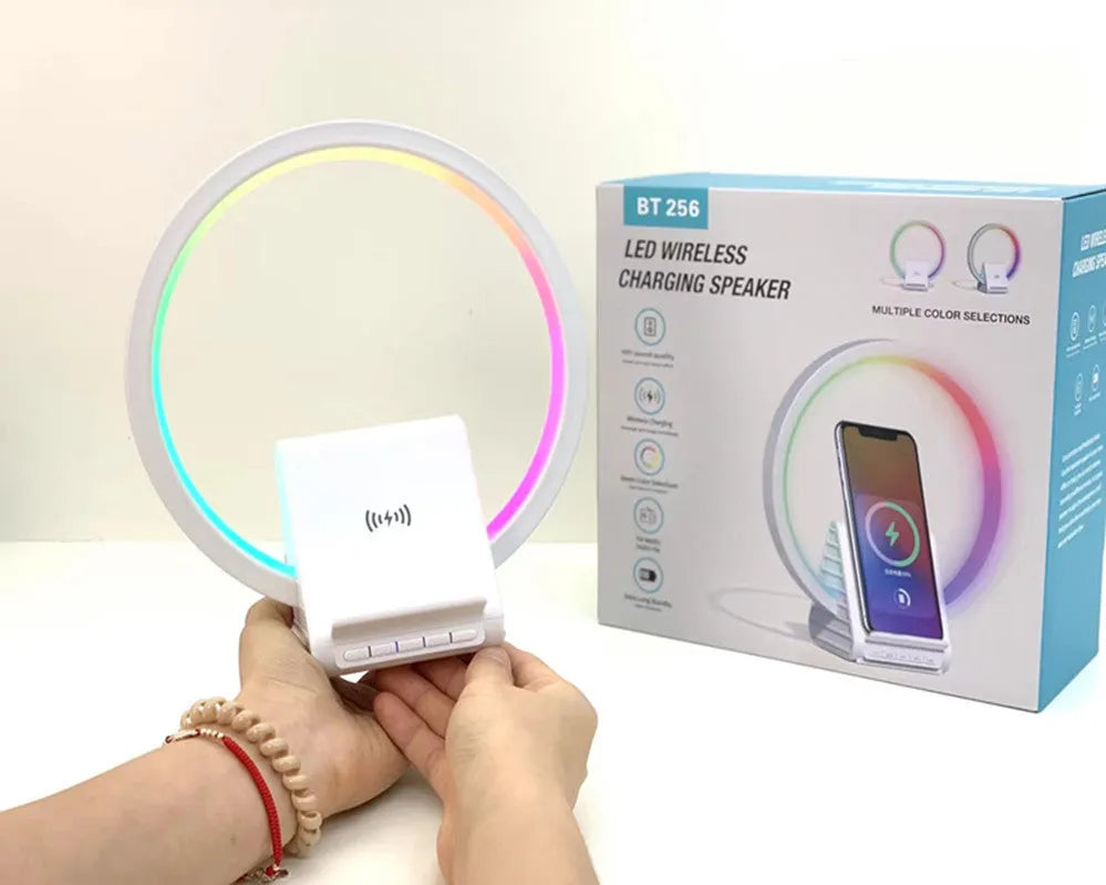 White smart Bluetooth speaker with wireless charging pad and ambient lighting on desktop