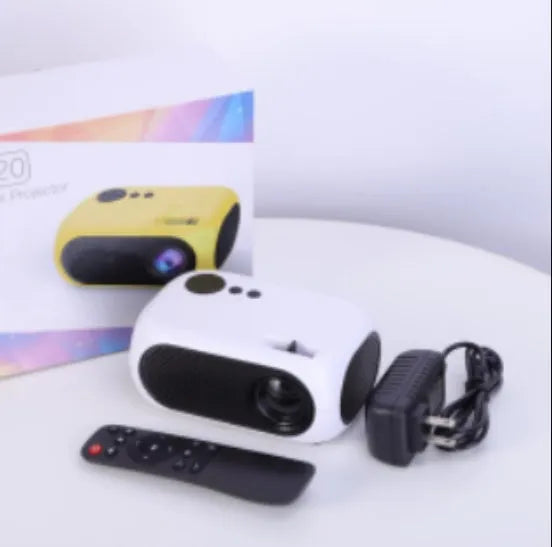 M24 gold and white micro mini portable LED projector with power adapter and AV cable on a grey background