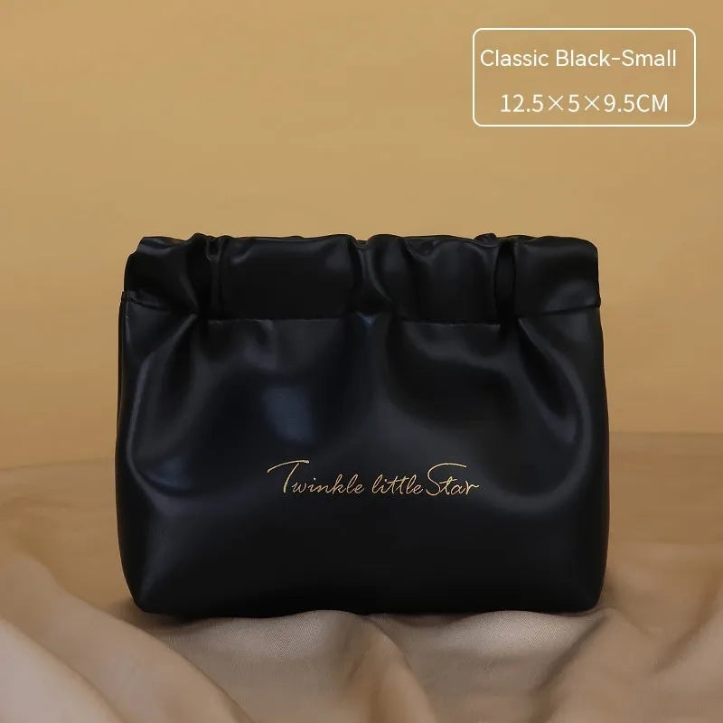 Large leather travel toiletry bag open to show dry and wet separation compartments.