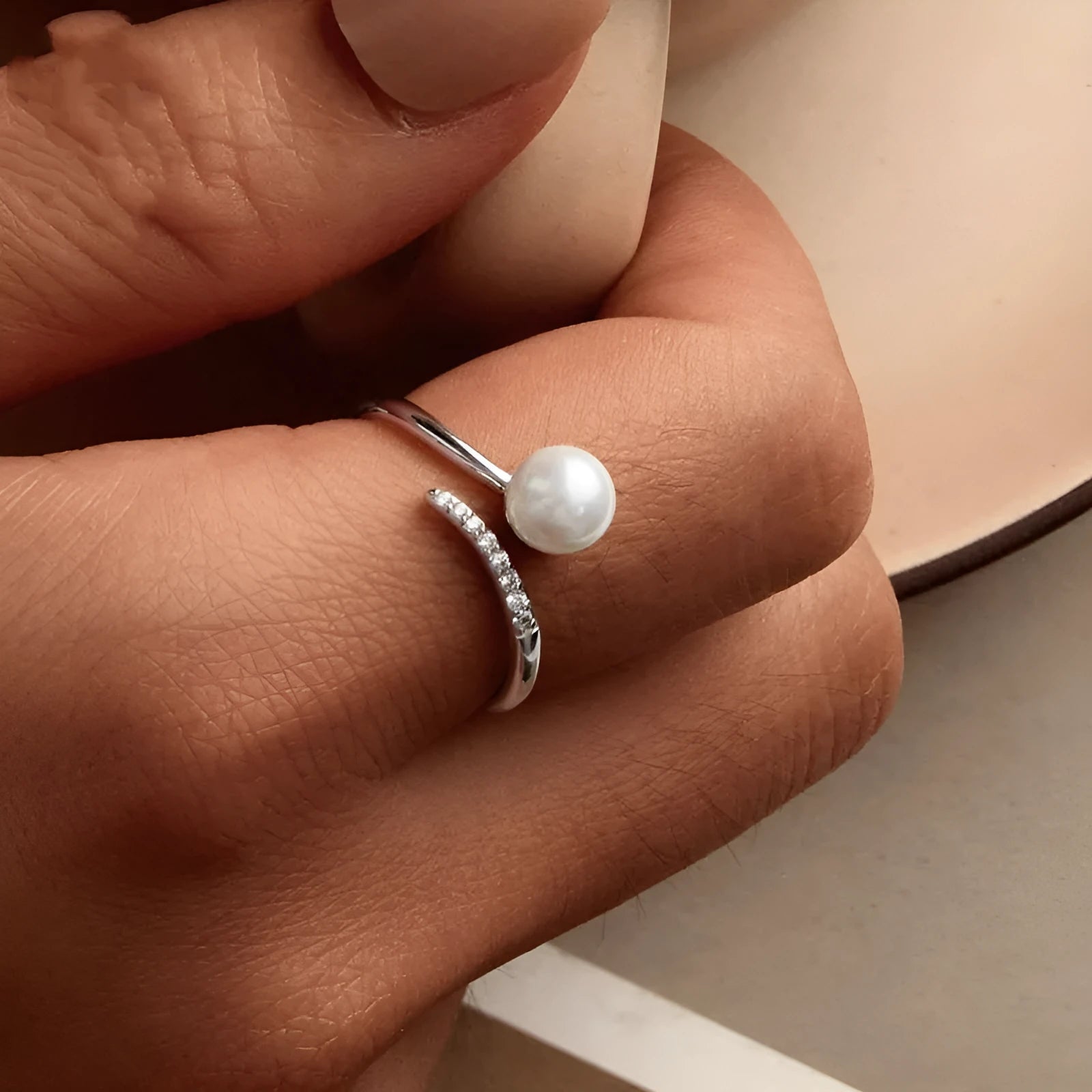 S925 sterling silver adjustable ring with a natural shell pearl on an open loop band.