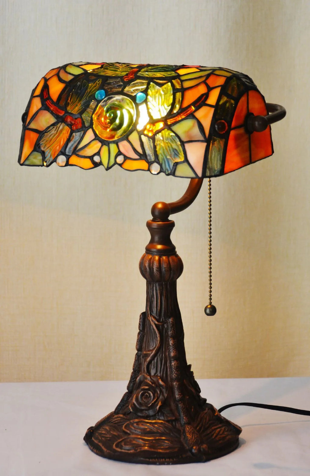 10-inch Tiffany stained glass table lamp with resin base on a wooden desk.