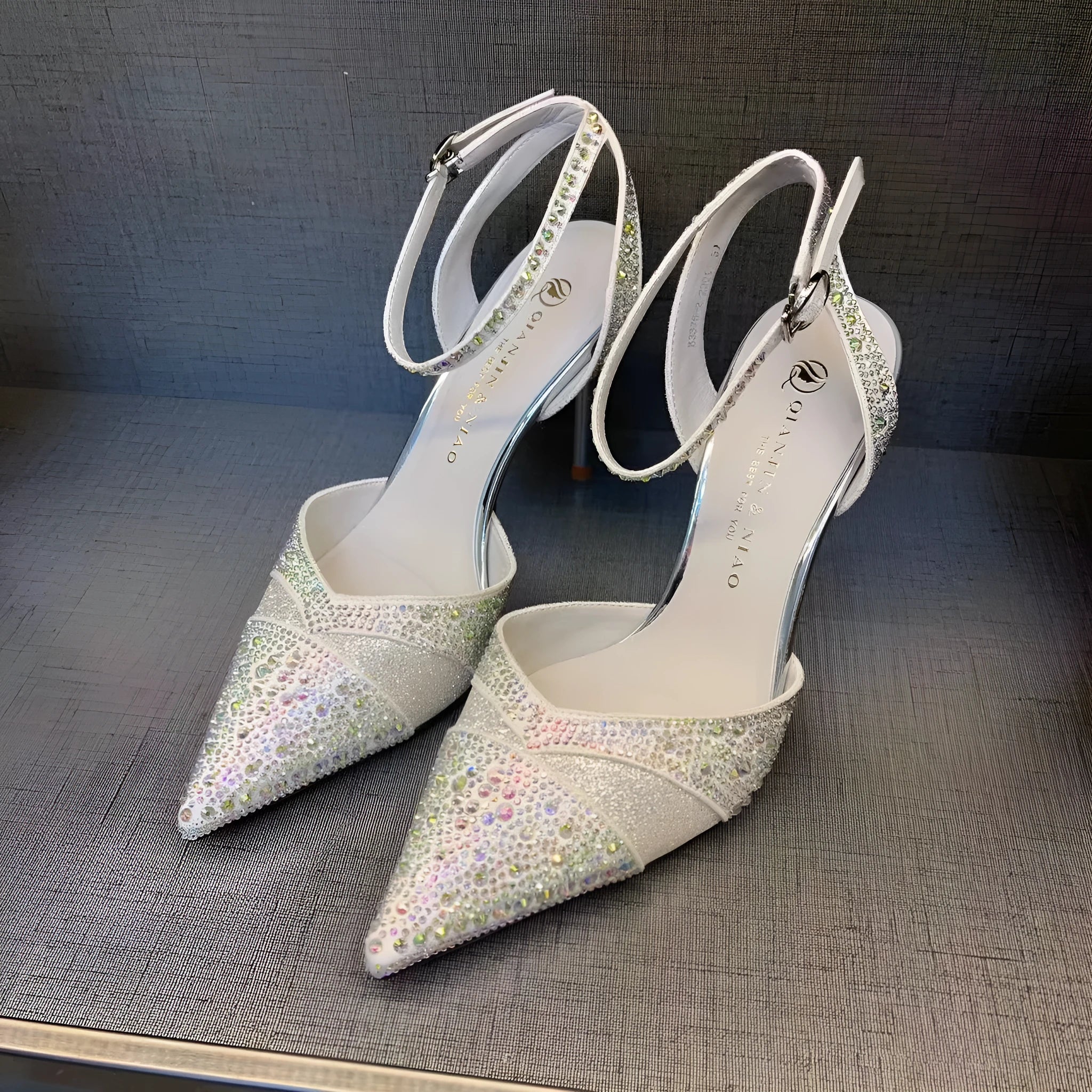 Women's black and silver hollow high heels with red soles, stiletto heels, and pointed toe design
