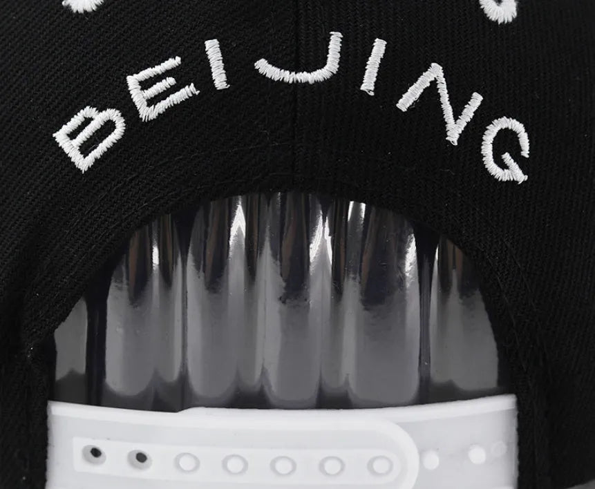 Cotton baseball cap with embroidered letters showing dome crown and adjustable back strap