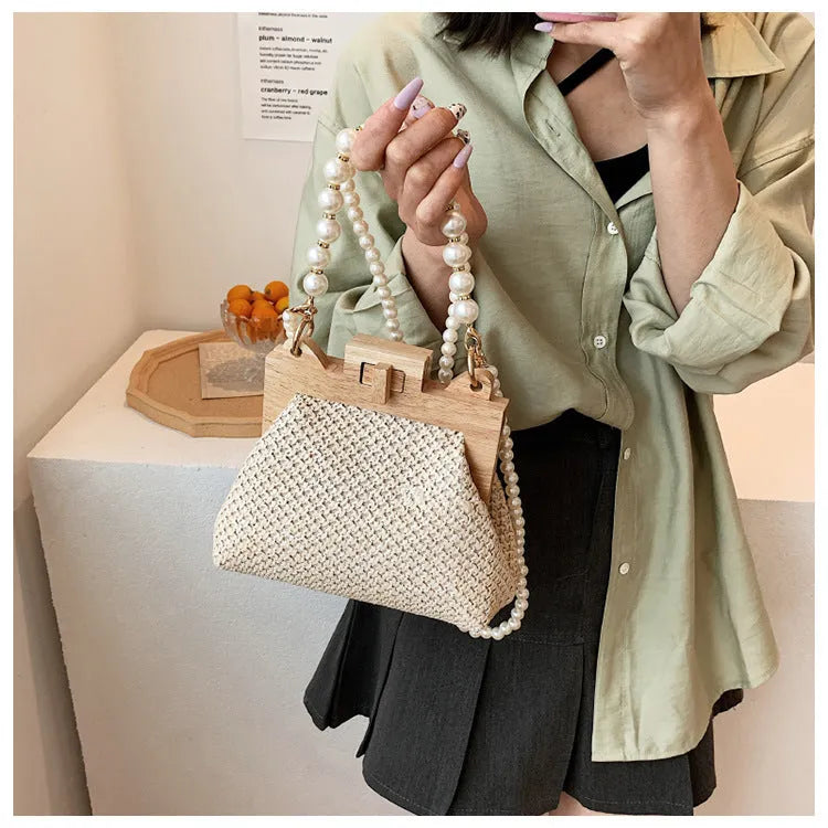 Women's woven straw shoulder bag with pearl chain strap in horizontal square shape